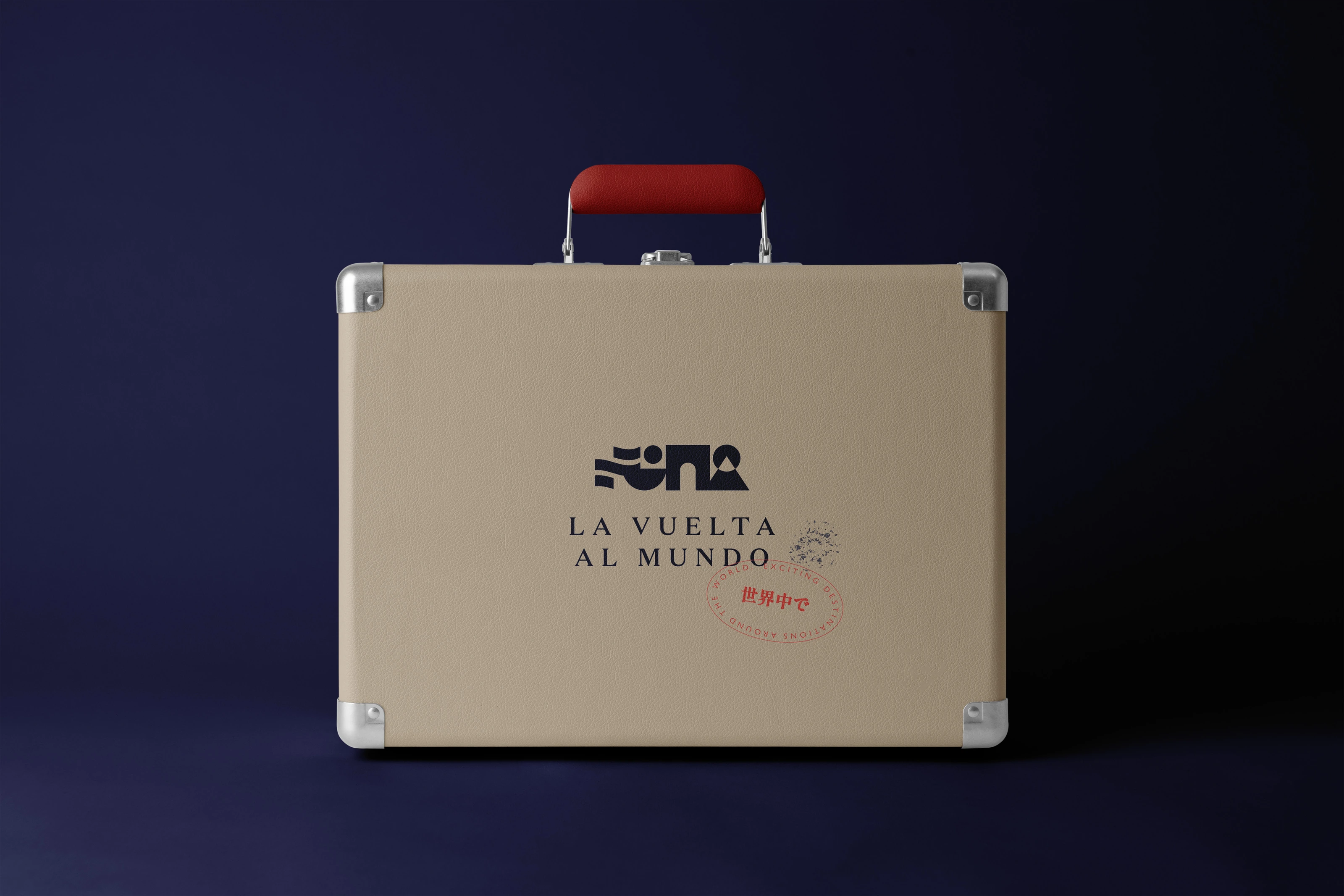 A sand-coloured suitcase with the La Vuelta al Mundo identity and travel stamp.