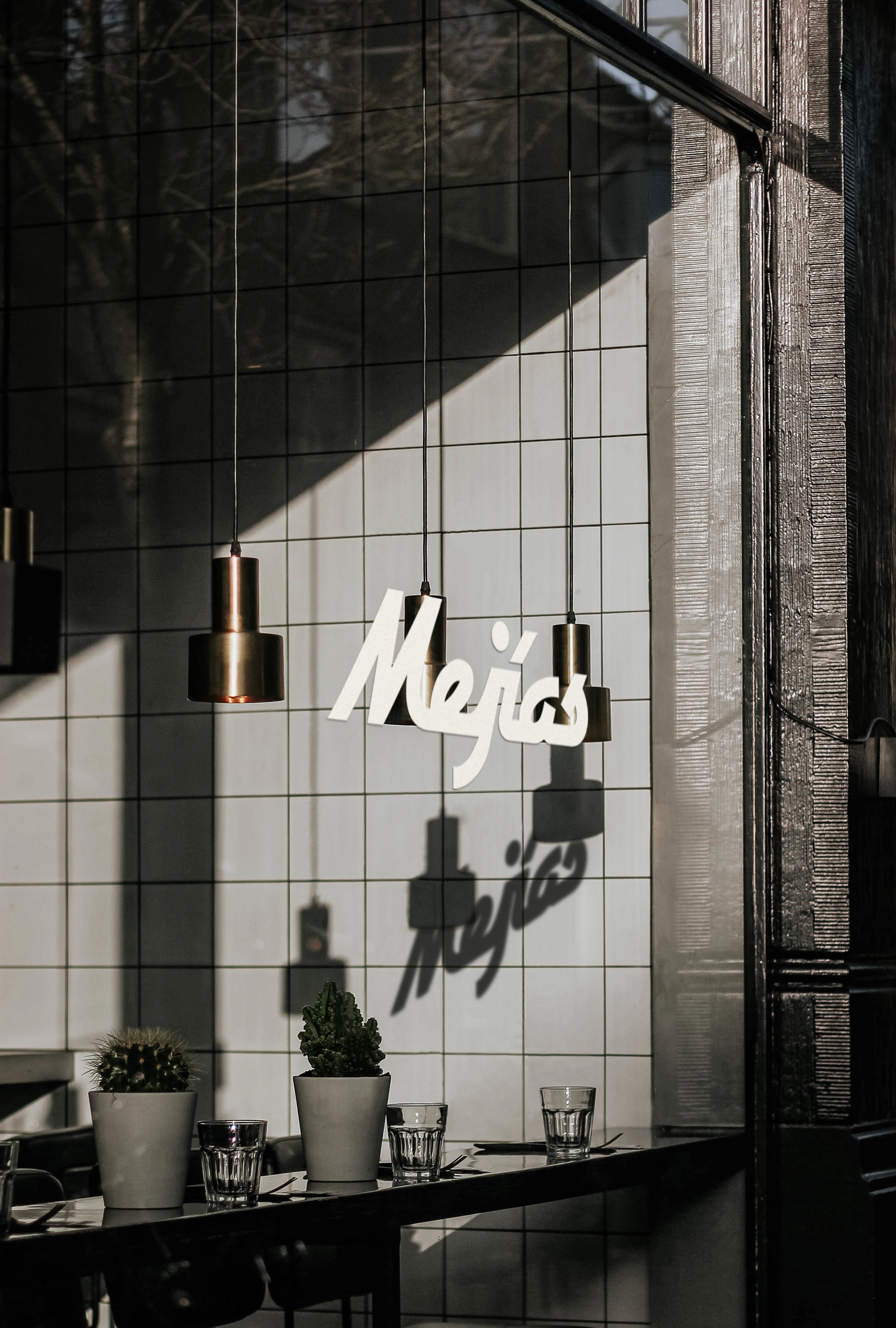 Mejías script lettering applied to a tiled studio window.