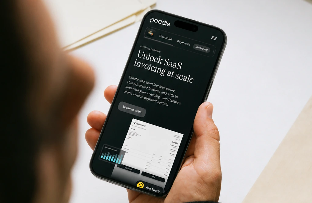 A person holding a phone displaying Paddle’s invoicing product page.