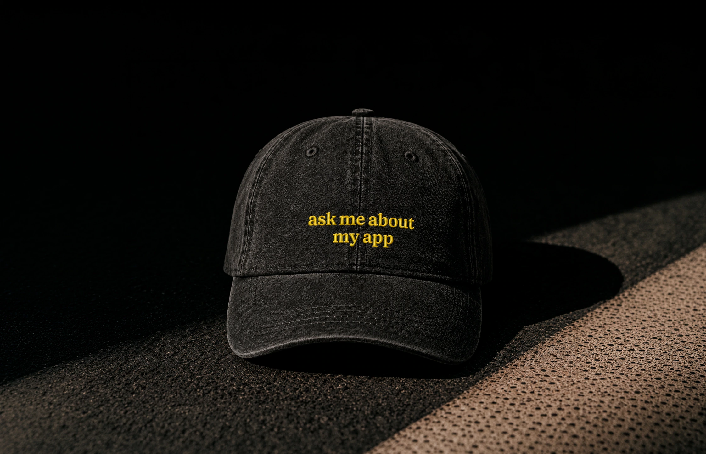 Black Paddle cap photographed on a textured dark surface.