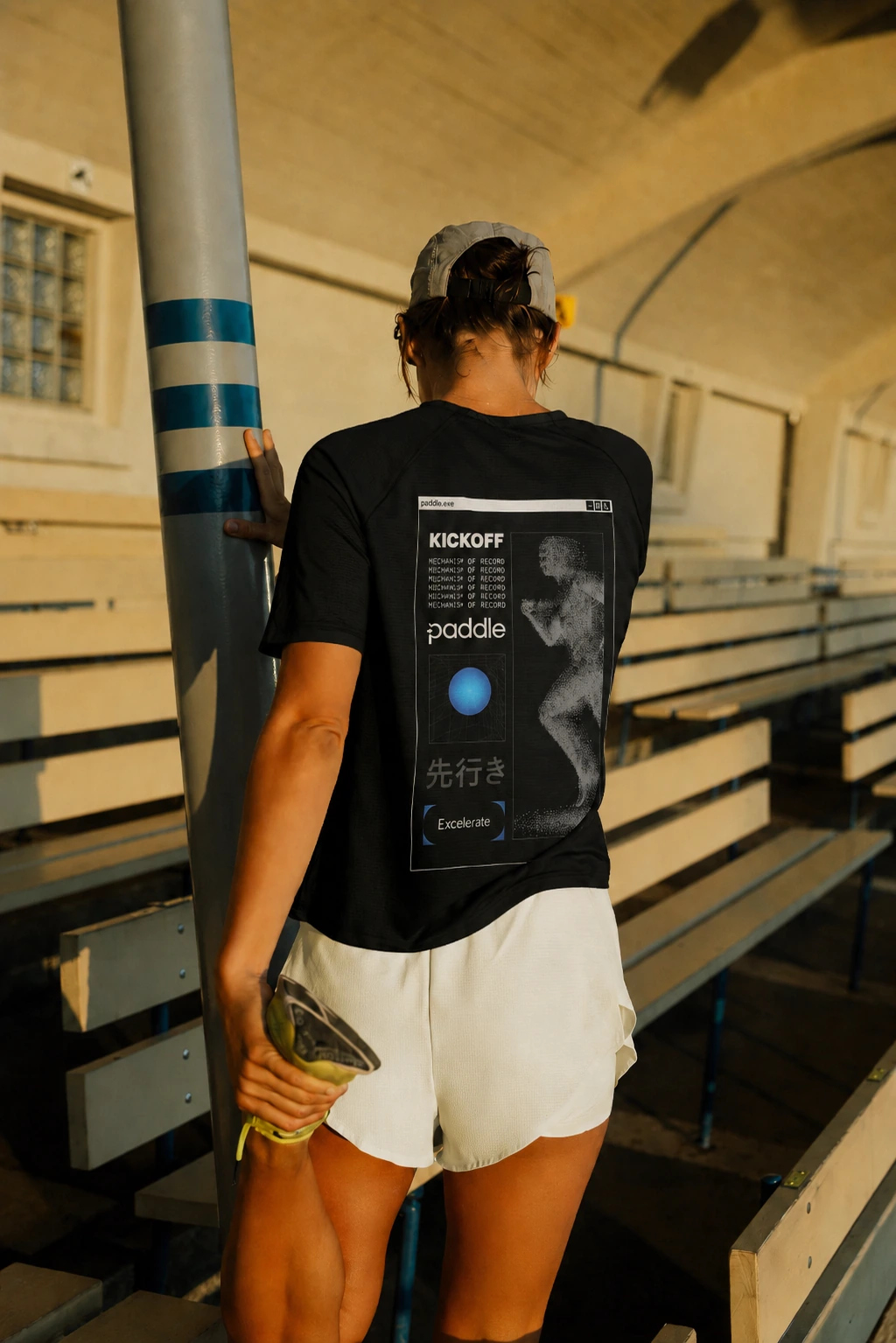 Athlete wearing a black Paddle kickoff shirt inside a sports venue.