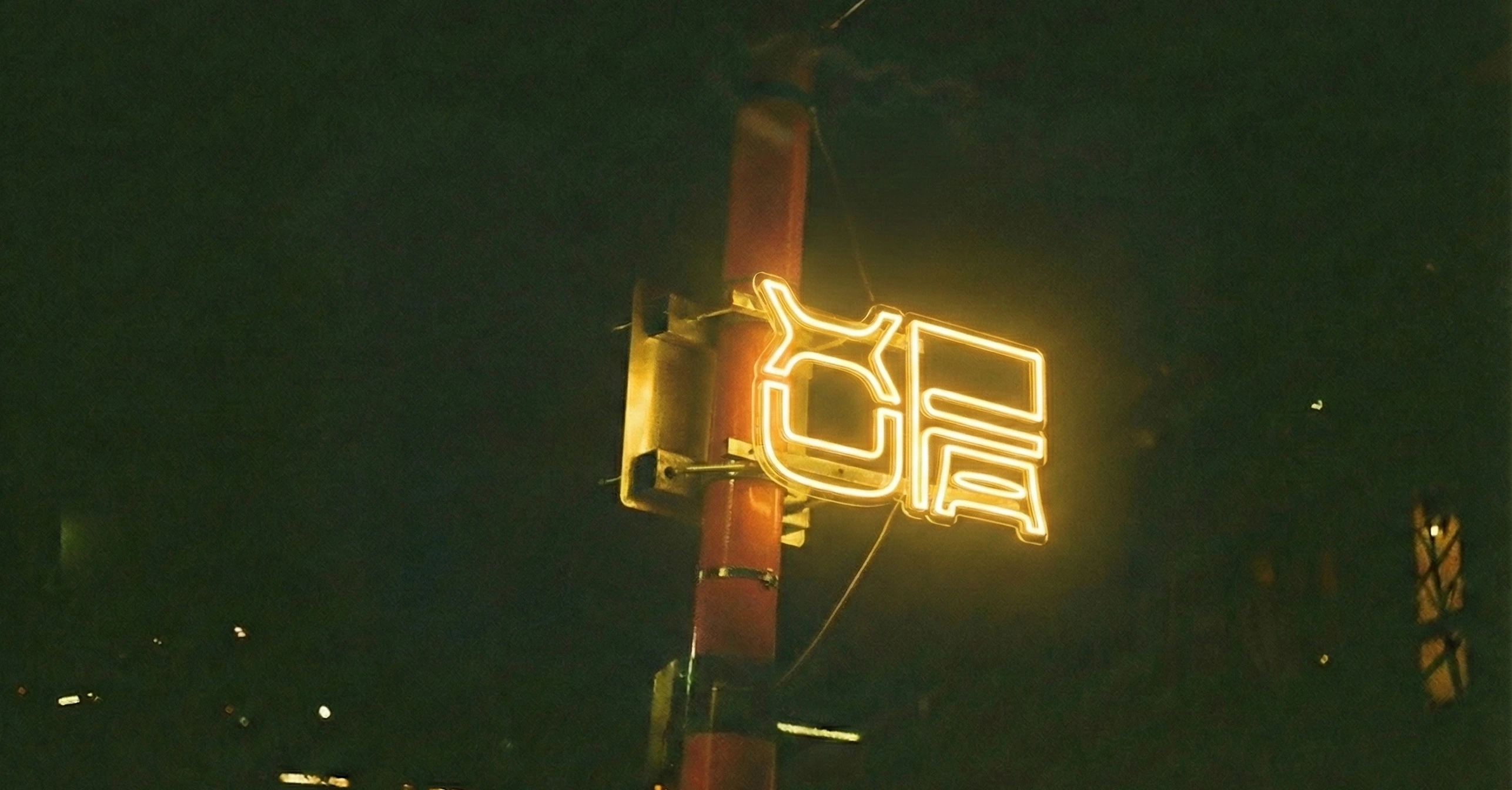 Yellow Xufa neon sign glowing on a dark building facade.